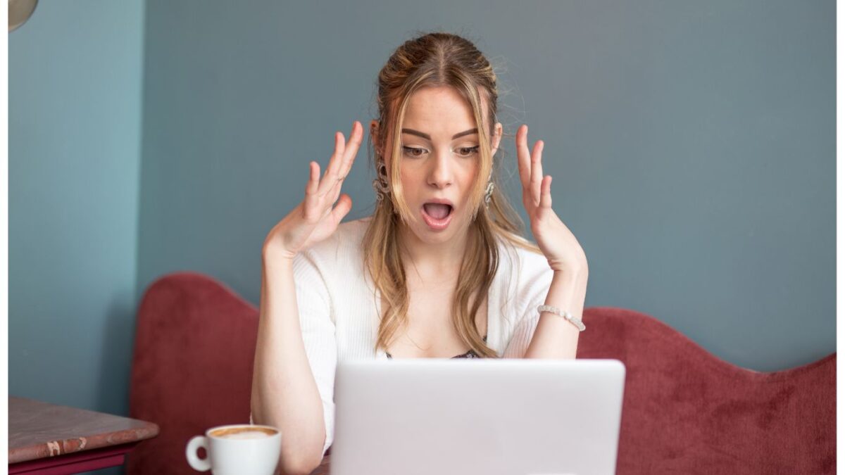 A woman sitting on the couch looking at her laptop